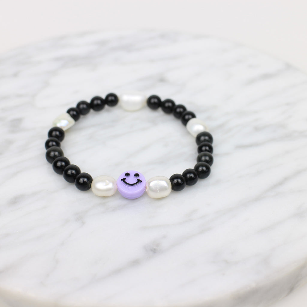 Black Smiley Armband. Schwarze Perlen, 5 weiße Süßwasserperlen und ein fliederner Smiley