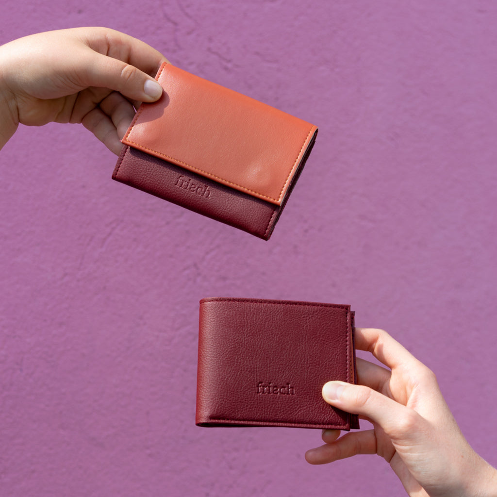 Zwei Hände halten die Brieftasche und den kleinen Geldbeutel