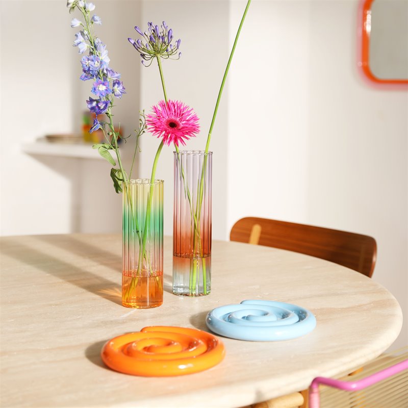 Zwei Glasvasen auf einem Tisch mit Blumen dekoriert