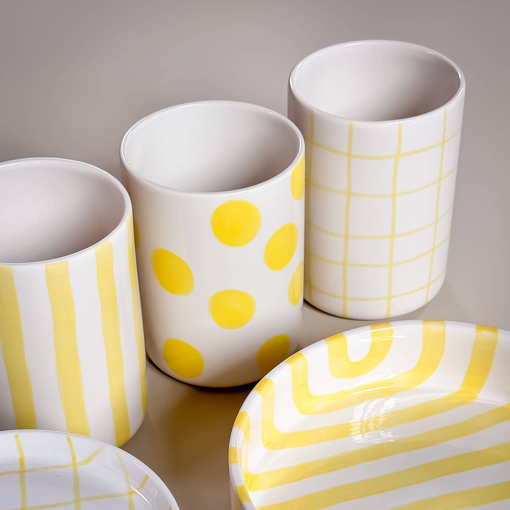 Vase Dots X Spiaggia Yellow, Detailansicht, 3 Vasen und zwei Teller nebeneinander mit unterschiedlichen gelben Mustern