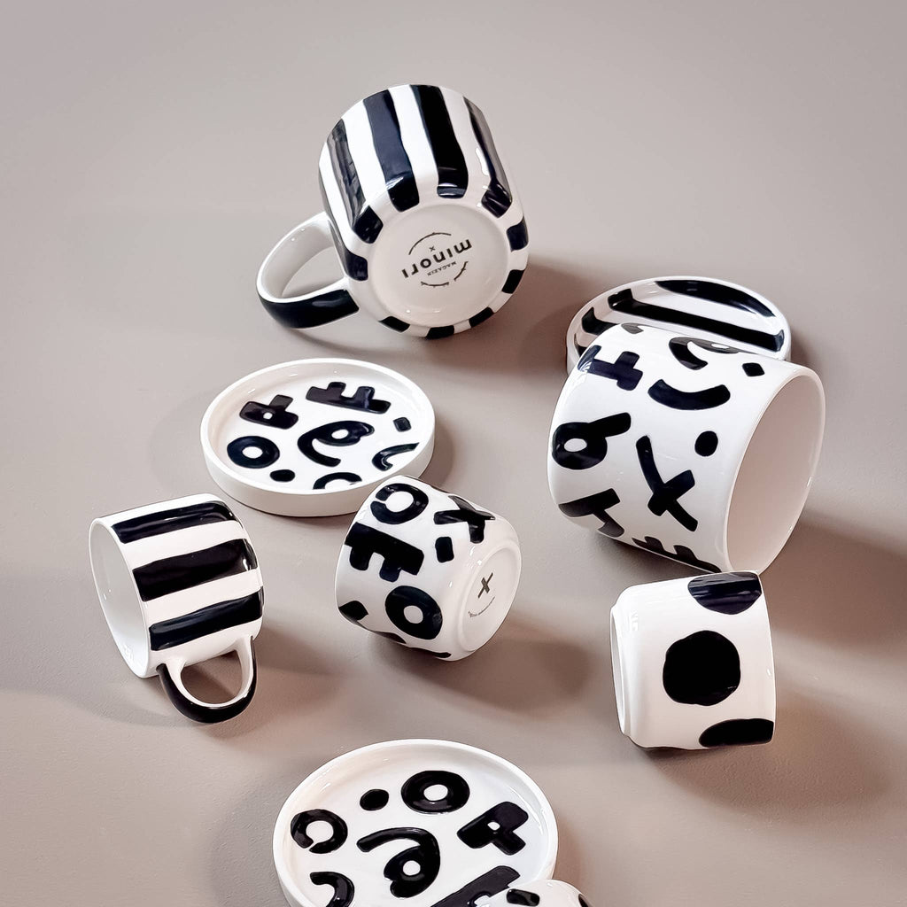 Magazin Minori, verschiedene schwarze Tassen und Untersetzer mit unterschiedlichen Mustern