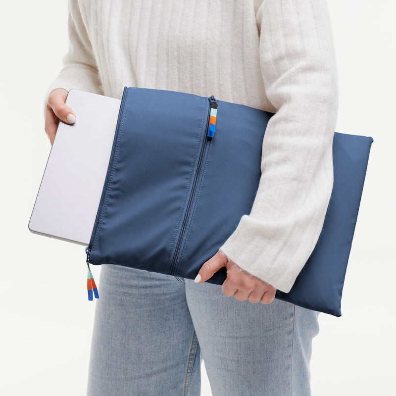 Ein Model steckt einen Laptop in die Laptoptasche