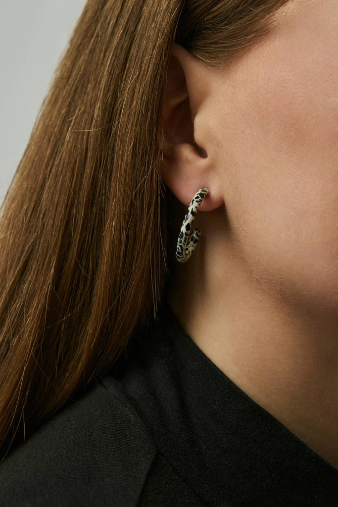 Loop Dott X Ohrringe, getragen von einem Model, Detailansicht