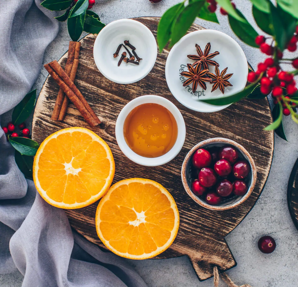 Eine Tasse mit Punsch, von oben fotografiert und dekoriert mit Orangen, Zimtstangen etc