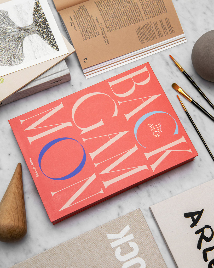 Backgammon dekoriert auf einem Tisch mit mehreren Büchern in Naturtönen und Pinseln