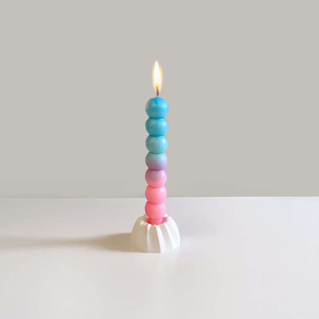 Bubbles-Kerze, brennend auf einem Gugelhupf-Kerzenständer