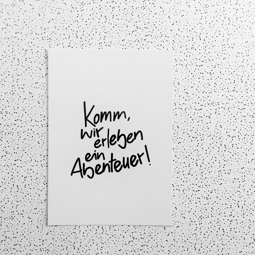 Weiße Postkarte mit schwarzer Schrift: Komm, wir erleben ein Abenteuer