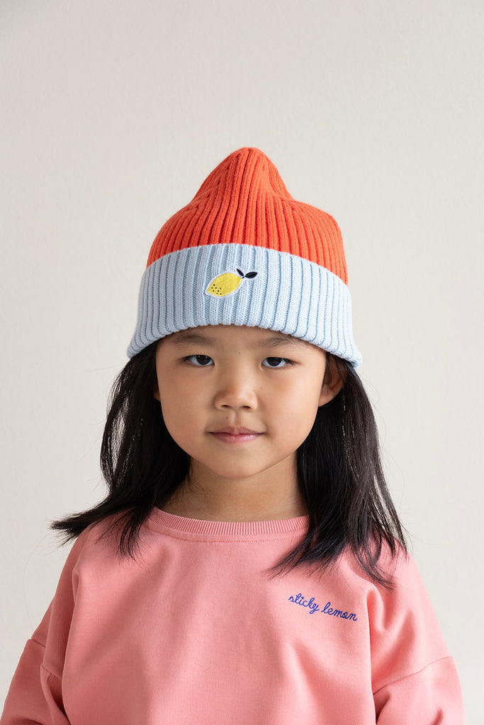 Rot & Hellblau X Beanie für Kinder, getragen von einem Kind, Frontansicht