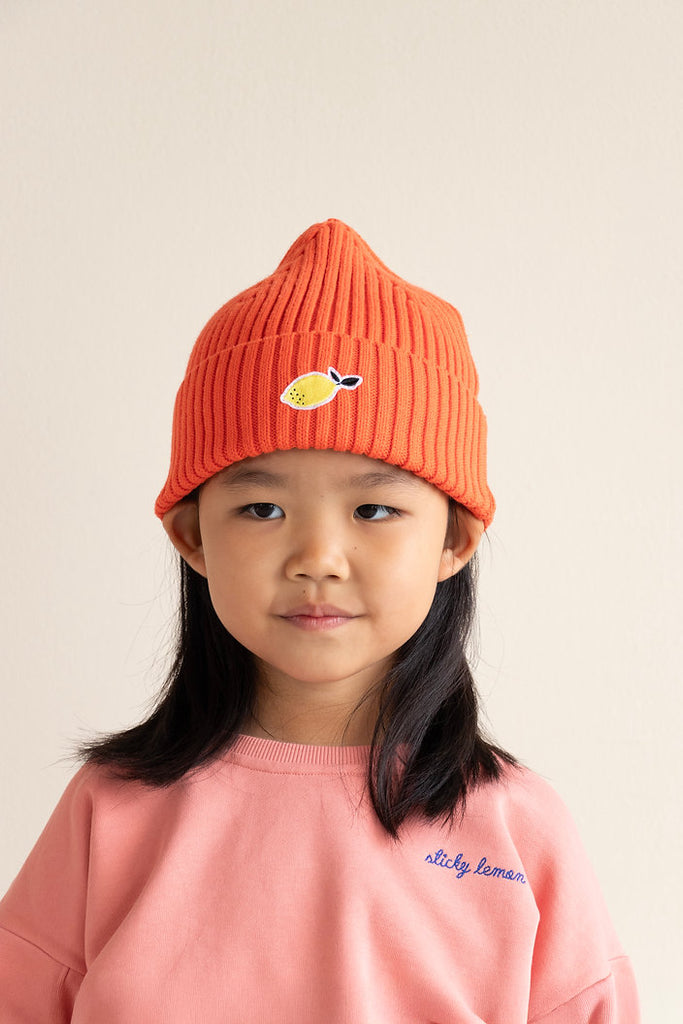 Rot X Beanie für Kinder, getragen von einem Kind, von vorn fotografiert