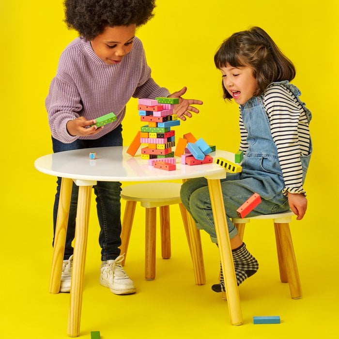 Zwei Kinder spielen am Tisch "stack a bug"