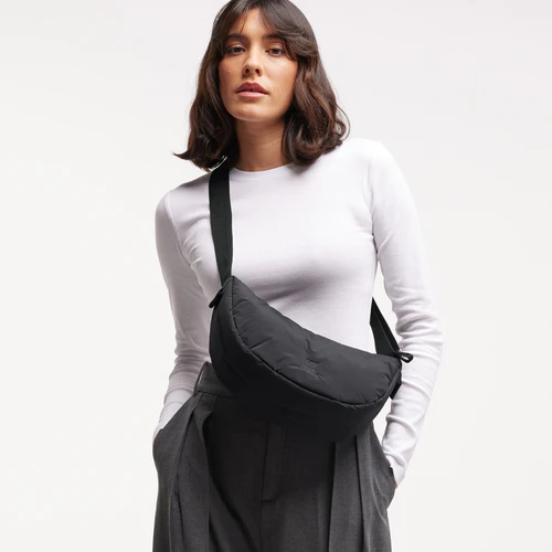 Ein Model trägt die Cloud Small Black X Monochrome Moon Bag crossbody