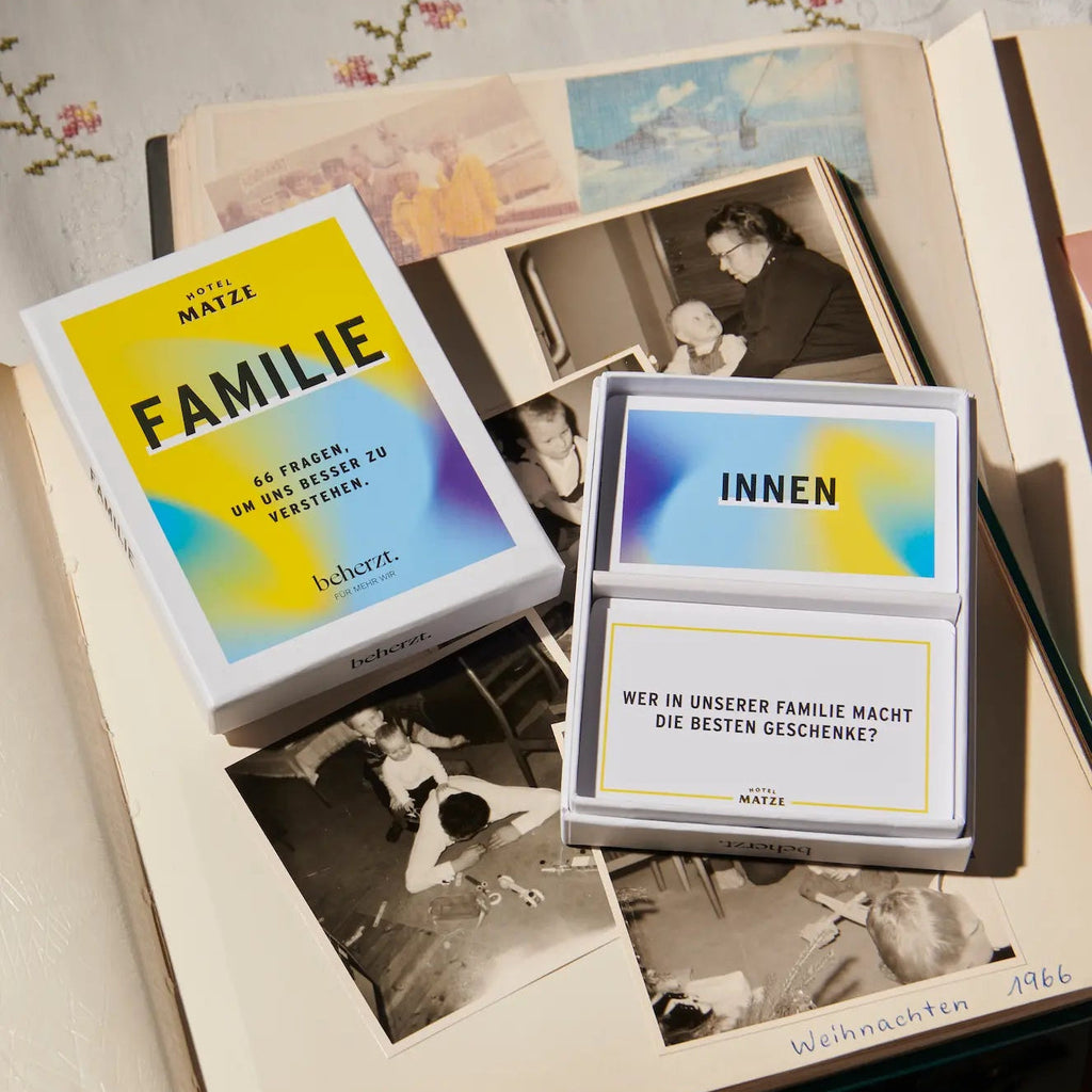 Familie X 66 Fragen, um uns besser zu verstehen, geöffnetes Spiel auf einem Familienfotoalbum