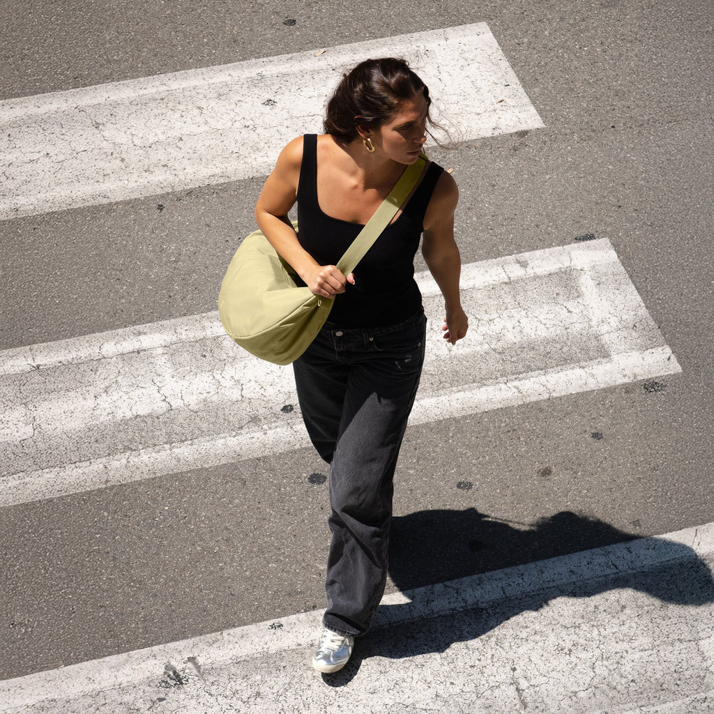 Large Nori Monochrome X Moon Bag, crossbody getragen von einem Model