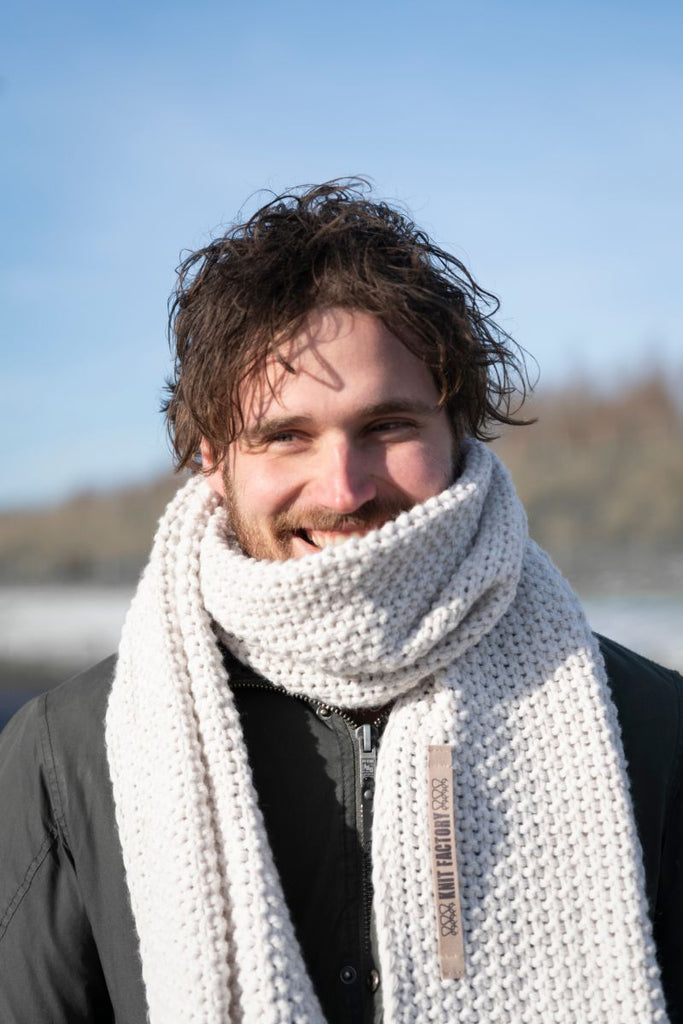 Ein Model trägt einen Schal in beige