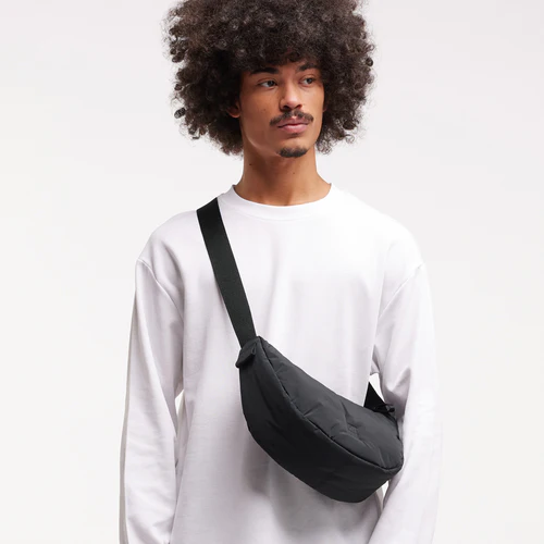 Ein Model trägt die Cloud Small Black X Monochrome Moon Bag crossbody