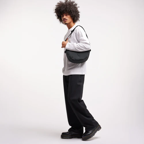 Ein Model trägt die Cloud Small Black X Monochrome Moon Bag über der Schulter