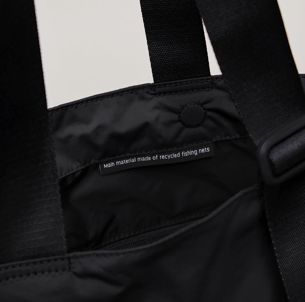 Detailansicht auf Etikett in der Tasche: "Main material made of recycled fishing nets"