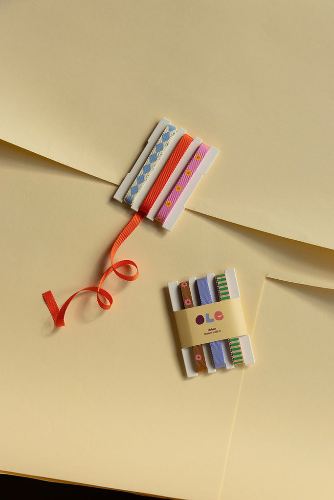 Raute-Uni-Blume X Geschenkband Set auf gelbem Papier mit einem anderen Geschenkband Set