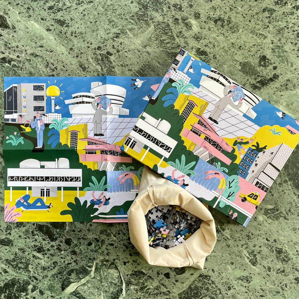 Architectural Masterpieces in Pieces Verpackungskarton und Puzzleteile auf grüner Tischplatte