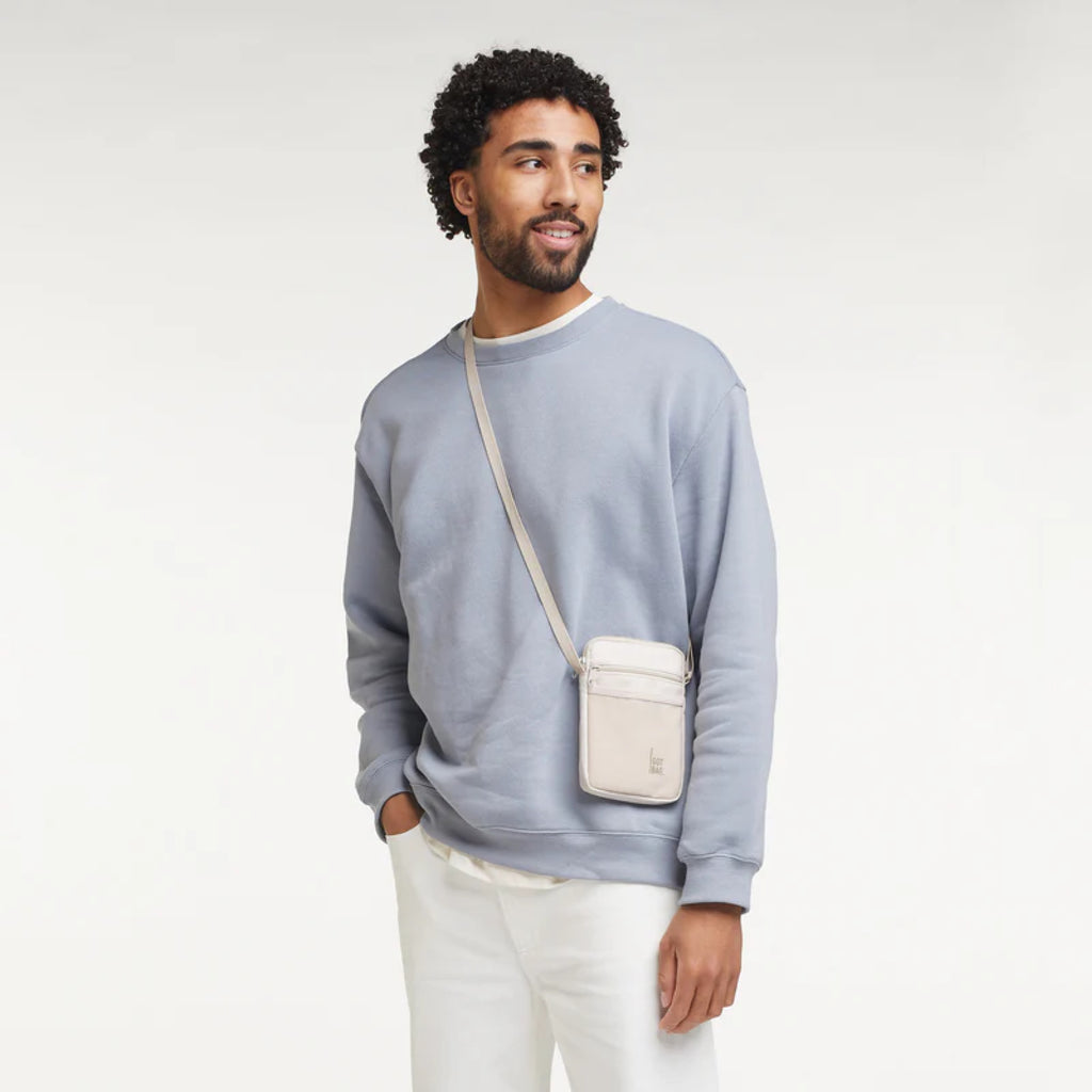 Nanobag Soft Shell (muschelweiß), ein Model trägt die Nanobag crossbody