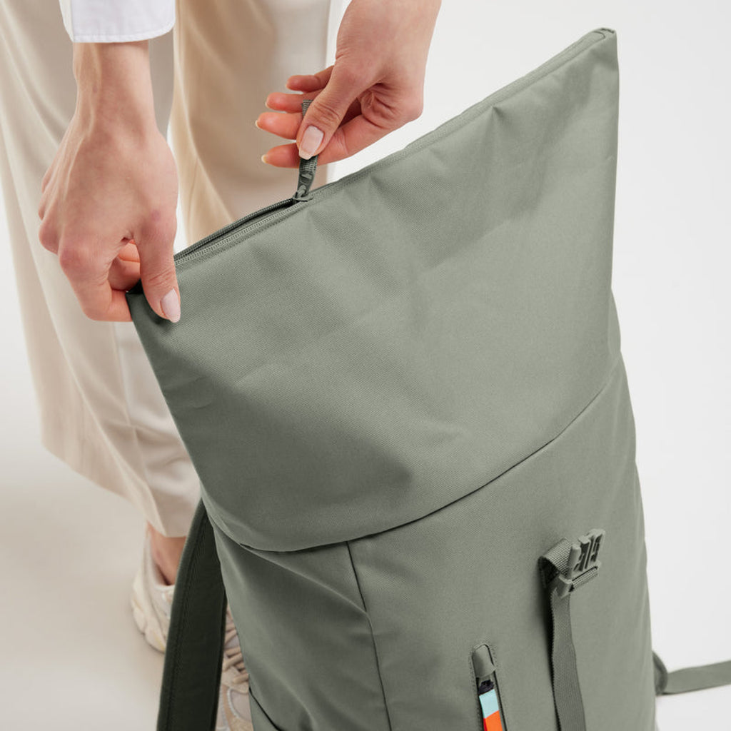 Easy Rolltop X Bass (hellgrün), Detailansicht, ein Model öffnet den Reißverschluss des Hauptfachs