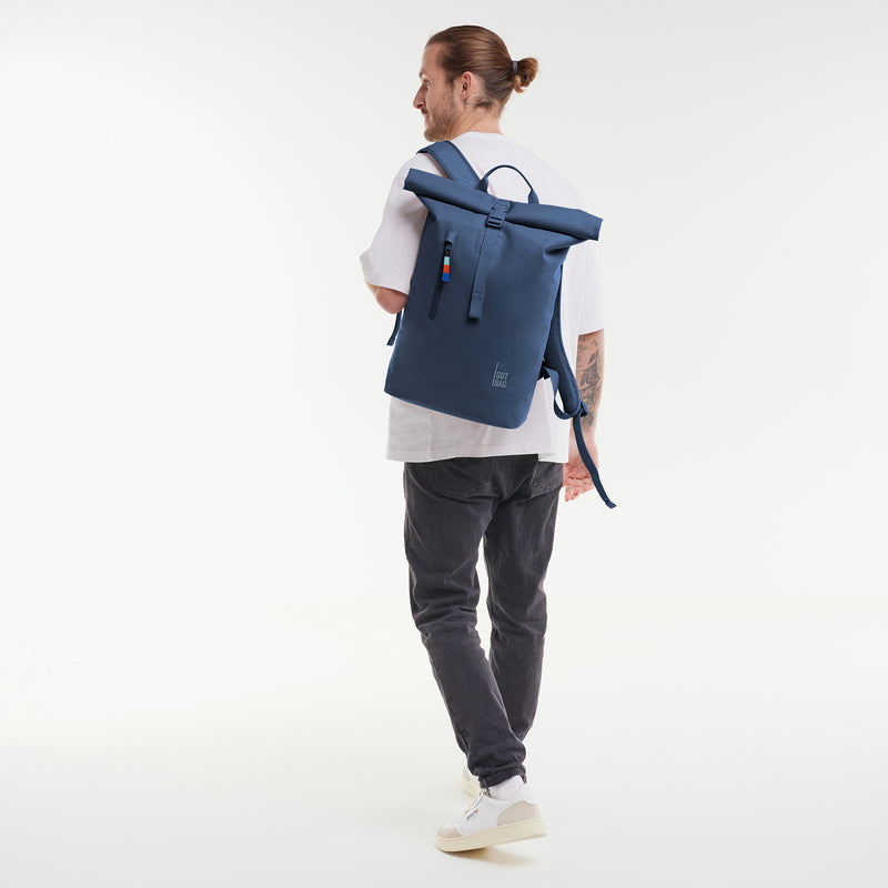Lite Rolltop 2.0 Ocean Blue (dunkelblau), auf einer Schulter getragen von einem Model