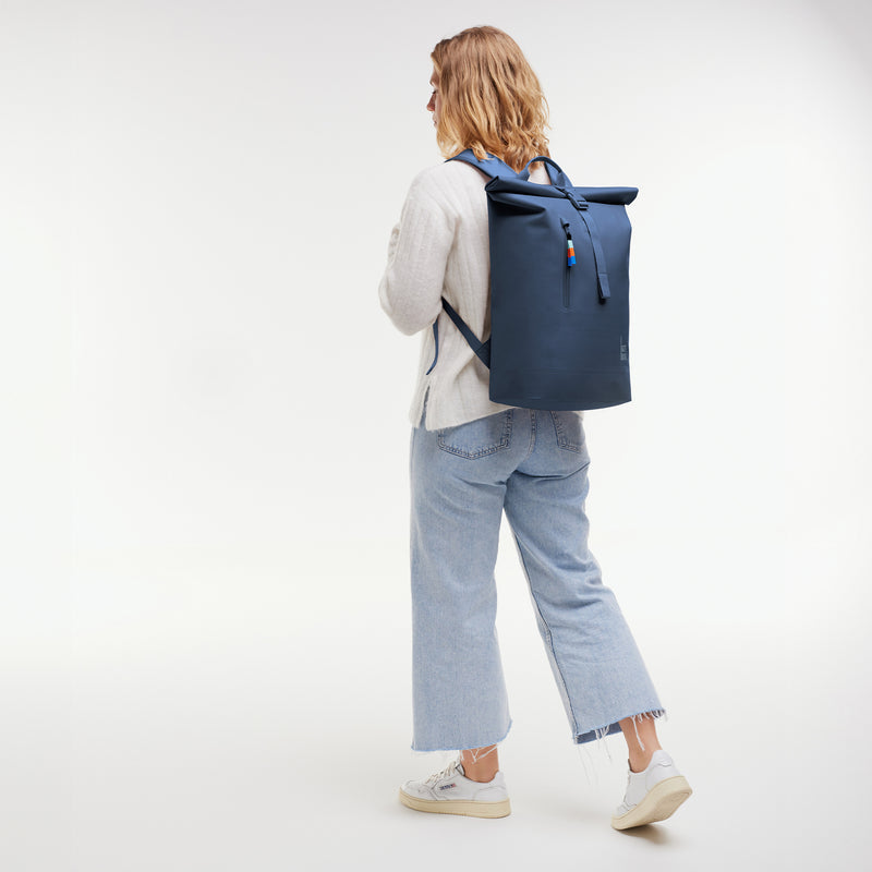 Lite Rolltop 2.0 Ocean Blue (dunkelblau), auf dem Rücken getragen von einem Model