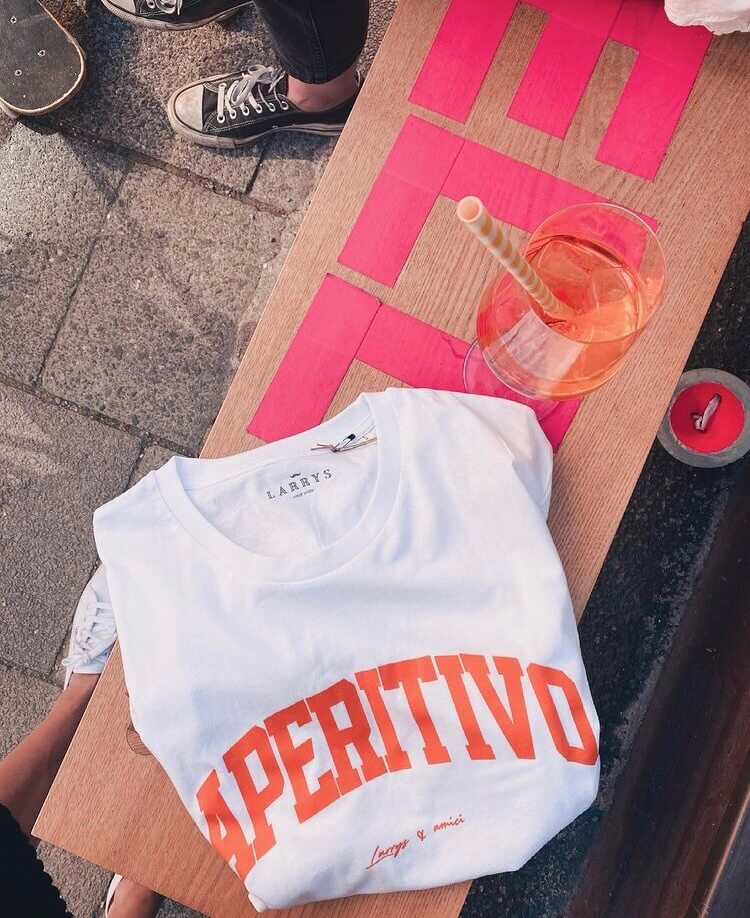 Weißes T-Shirt mit orangenem Print "Aperitivo" auf der Brust im College-Style